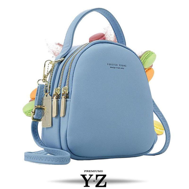 Bold and elegant, the Macaron Collection is one of our favorites. Made with soft, smooth faux-leather, it features a modern, versatile design that styles up any outfit with effortless elegance. The luxurious golden zippers and tags create a stunning accent against the classy body. Spacious and practical in its design, this cross-body strapped shoulder bag is perfect for carrying your essentials as you head out for an evening filled with fun, excitement, and adventure.