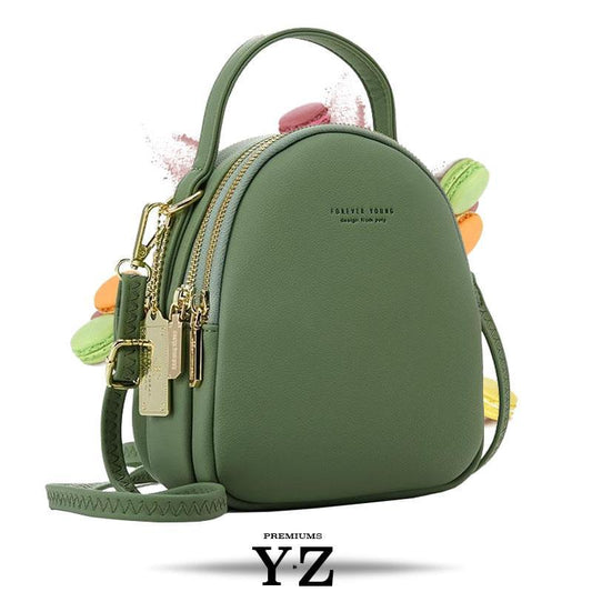 Bold and elegant, the green macaron is one of our favorites. Made with soft, smooth faux-leather, it features a modern, versatile design that styles up any outfit with effortless elegance. The luxurious golden zippers and tags create a stunning accent against the classy green body. Spacious and practical in its design, this cross-body strapped shoulder bag is perfect for carrying your essentials as you head out for an evening filled with fun, excitement, and adventure.
