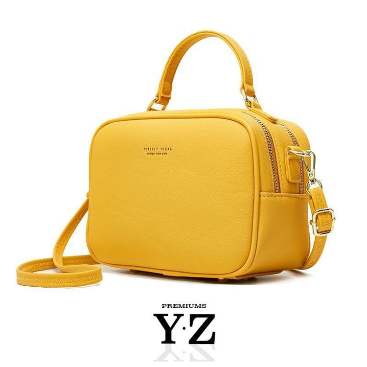 The Signature Handbag has four points in the bottom that ensure a well-balanced bag when not holding the bag. Gold-colored zippers create a shiny style hidden in the details. With a font "Young Forever" with the same color tone as the zippers, gives us the message that stylish Signature handbag is adaptable regardless of age and experience. Inside, we find two equally large pockets in the handbag that offer very good space for everything one would need for an important and charming occasion.