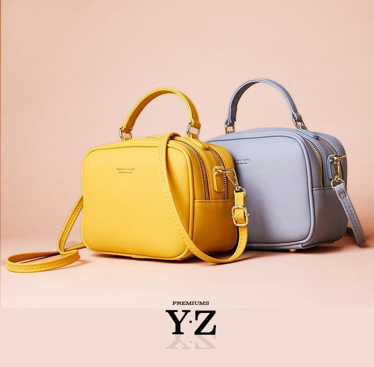 The Signature Handbag has four points in the bottom that ensure a well-balanced bag when not holding the bag. Gold-colored zippers create a shiny style hidden in the details. With a font "Young Forever" with the same color tone as the zippers, gives us the message that stylish Signature handbag is adaptable regardless of age and experience. Inside, we find two equally large pockets in the handbag that offer very good space for everything one would need for an important and charming occasion.